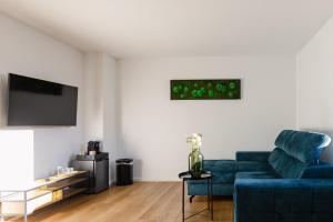 瓦尔内明德Alex & Rine - Pension Zum Alten Strom的客厅配有蓝色的沙发和电视