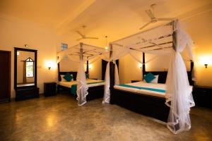 希克杜沃国际海滩餐厅酒店 的一间卧室配有两张带蚊帐的床