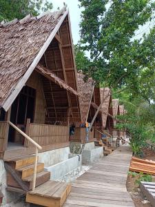 KriWarahnus dive homestay的一组有木台阶和树木的房屋