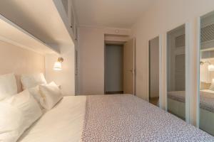 比亚里茨Appartement de 50 m2 à quelques mètres des commerces et des plages的一间卧室配有带白色床单和枕头的床。