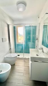卡尔德杜Mare Azzurro的一间带两个盥洗盆、浴缸和卫生间的浴室