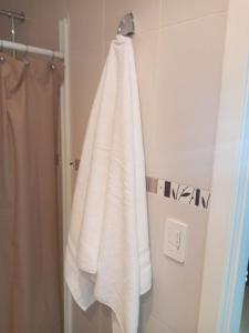 基多Bella Suit amoblada, sector exclusivo La Carolina.的浴室内挂在架子上的白色毛巾