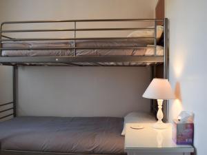 EatonThe Flat的一间卧室设有两张双层床和一张带台灯的桌子