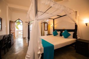 希克杜沃国际海滩餐厅酒店 的一间卧室配有一张带天蓬的床