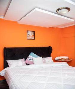 KazungulaKasbek Lodge & Tours的一间卧室配有一张橙色墙壁的床