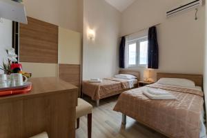 斯塔利格拉德-帕克利尼卡Argyruntum Apartments的酒店客房设有两张床和一张桌子及柜台。