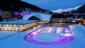 克洛斯特斯斯戴恩贝克酒店的一座在夜间雪地里设有溜冰场的建筑