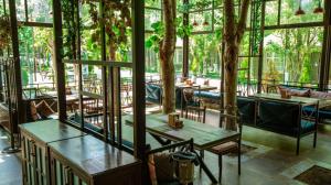纳布兰VOGUE HOTEL RESORT AND SPA - Nabran的一间设有桌椅的餐厅,位于带窗户的房间内