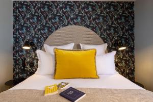 巴黎Hotel Fior d'Aliza的一张带黄色枕头的床和一本书
