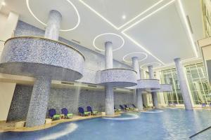赫尔格达Pickalbatros Blu Spa Resort - Adults Friendly 16 Years Plus- Ultra All-Inclusive的大型大堂设有蓝色椅子和大型吊灯