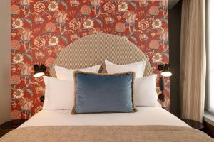 巴黎Hotel Fior d'Aliza的一间卧室配有一张带蓝色枕头的床