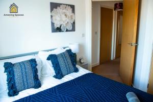 沃灵顿Cosy 2 Bed Flat Sleeps 4 with Free Parking by Amazing Spaces Relocations Ltd的一间卧室配有一张带蓝色和白色枕头的床