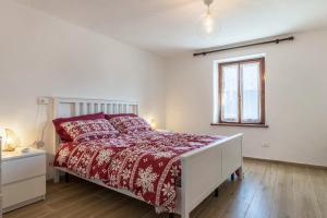 福尔加里亚Appartamento Edik的一间卧室配有一张带红色棉被的床和窗户。