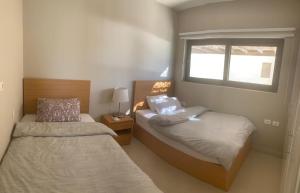 赫尔格达Tawila, 4 Bedroom Villa, Brand new, directly on a lagoon的一间卧室设有两张床和窗户。