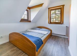 RaduńZielony Domek na skarpie的一间卧室设有一张床和两个窗户。