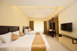VandiperiyārThekkady Gavi Suites的一间酒店客房,配有一张大床和一台平面电视