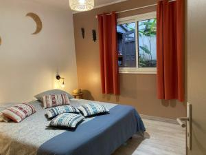 圣勒Bungalow Tec-Tec St Leu的卧室配有带枕头的床铺和窗户。