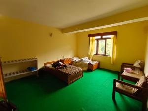 PemayangtseHotel Pemathang的一间设有两张床的客房,位于绿色的地板上