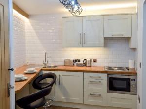 格洛索普Chunal Apartment - Uk12958的厨房配有白色橱柜和黑椅