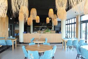 科沃布热格Apartamenty BalticON Polanki Aqua的一间配备有蓝色桌椅和吊灯的餐厅