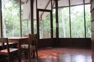 塔拉波托La Musa Verde的一间带桌椅和窗户的用餐室