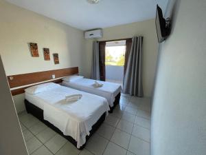 圣若泽-达科罗阿格兰迪Pousada Costa dos Corais的酒店客房设有两张床和电视。