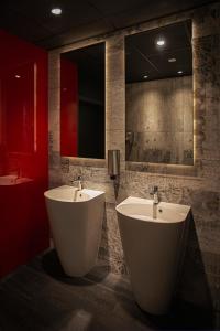 罗兹Abton Hotel的一间带两个盥洗盆和大镜子的浴室