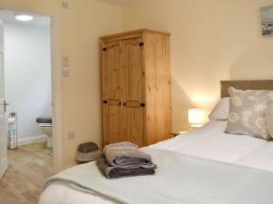 斯泰兹Drake Lodge的一间卧室配有一张床和一个木制橱柜