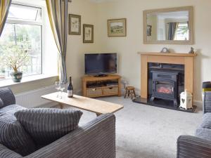 雷德迈尔Grassgarth Cottage的带沙发和壁炉的客厅