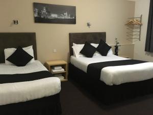 利物浦Lord Nelson Hotel的酒店客房带两张床铺以及黑白枕头