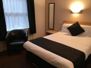 利物浦Lord Nelson Hotel的配有一张床和一把椅子的酒店客房