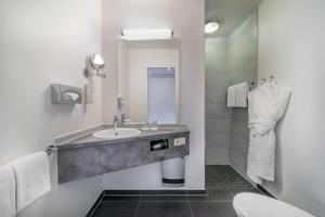 奥伯豪森Hotel Oberhausen Neue Mitte affiliated by Meliá的一间带水槽和卫生间的浴室