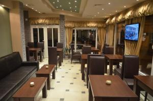 雅戈丁那Garni Hotel Lion的一间带桌椅和电视的餐厅