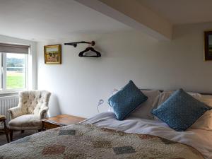 EatonMoss Hall Barn的一间卧室配有一张带蓝色枕头的床。