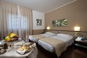 巴勒莫阿斯托瑞亚宫酒店的酒店客房设有两张床和一张带一碗水果的桌子。