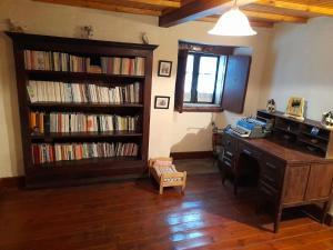 卢戈Albergue Rectoral de Romean的一间设有书桌的房间和书架