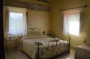 San Pier NicetoValle degli Agrumi的一间卧室设有一张床和两个窗户。