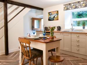 SilsdenBeckside Cottage的厨房配有木桌、椅子和水槽