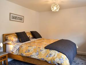 SilsdenBeckside Cottage的一间卧室配有一张带被子的床