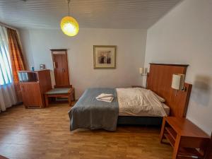 普莱滕贝格Hotel Restaurant Hüftgold的卧室配有1张床、1张桌子和1把椅子