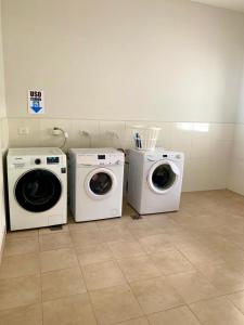 内乌肯Los Cardos Suites的客房内的3台洗衣机和干衣机