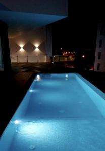 明德卢Luna Boutique Hotel的一座游泳池晚上在大楼里点燃