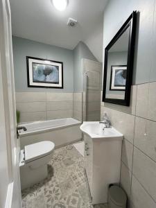 DundrumTonn Ruray Sea View Luxury 2 Bed Apartment的浴室配有卫生间、盥洗盆和浴缸。