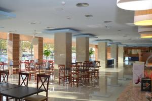雷乌斯雷乌斯公园酒店的大楼内带桌椅的用餐区