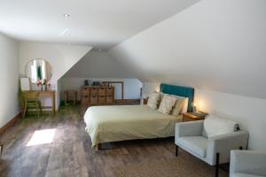 卢斯拉斯格兰维度假屋的一间卧室配有一张床、一把椅子和镜子