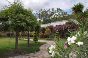 伊瓦拉Lujosa Quinta Vacacional Ibarra的种有树木和鲜花的花园以及步道