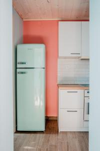 费索斯Με θέα το ηλιοβασιλεμα 2的厨房里设有白色冰箱,墙壁橙色