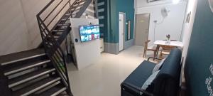 峇六拜Wifi 100Mbps+Netflix - Wau Bulan Flies @ The CEO的一间带楼梯和电视的客厅