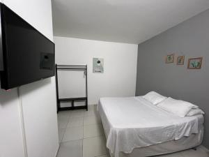 莱蒂西亚Hotel Estadio Exprés的一间卧室配有一张床和一台平面电视