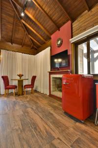 格拉玛多Stillo Gramado Dutra的客厅配有红色冰箱和桌子